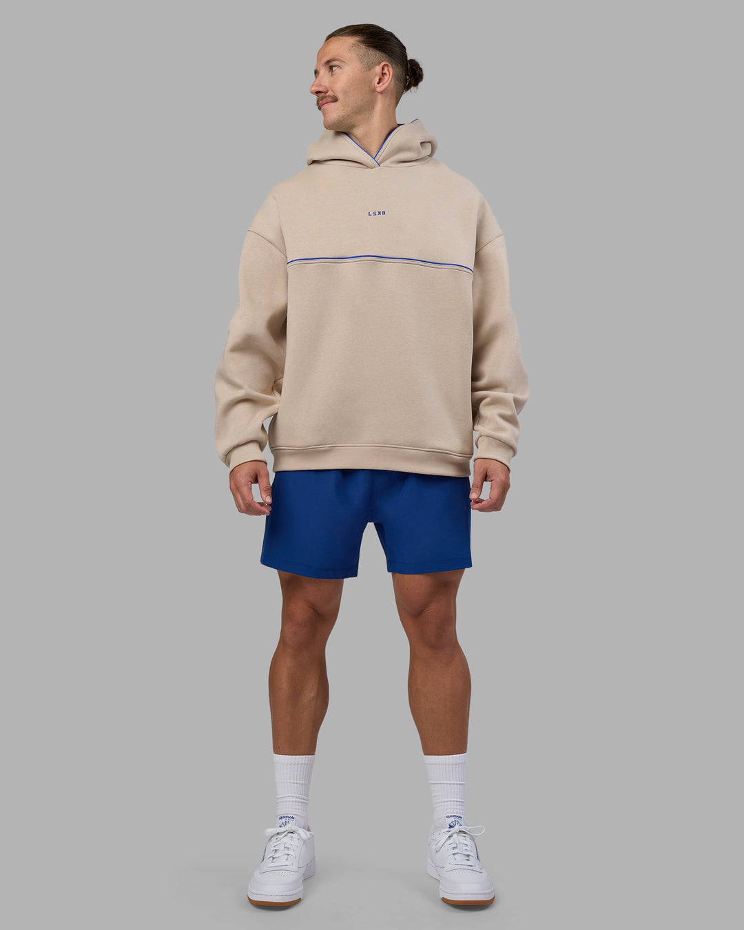 Man wearing Unisex Oversized Piping Hoodie - Shale Beige-Power Cobalt | Model:Jaiden | Size:M