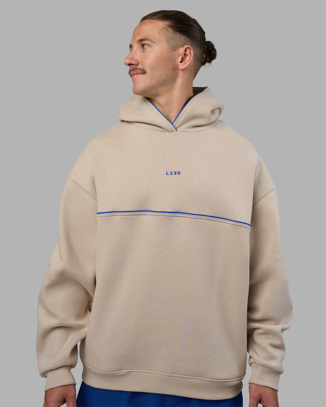 Man wearing Unisex Oversized Piping Hoodie - Shale Beige-Power Cobalt | Model:Jaiden | Size:M