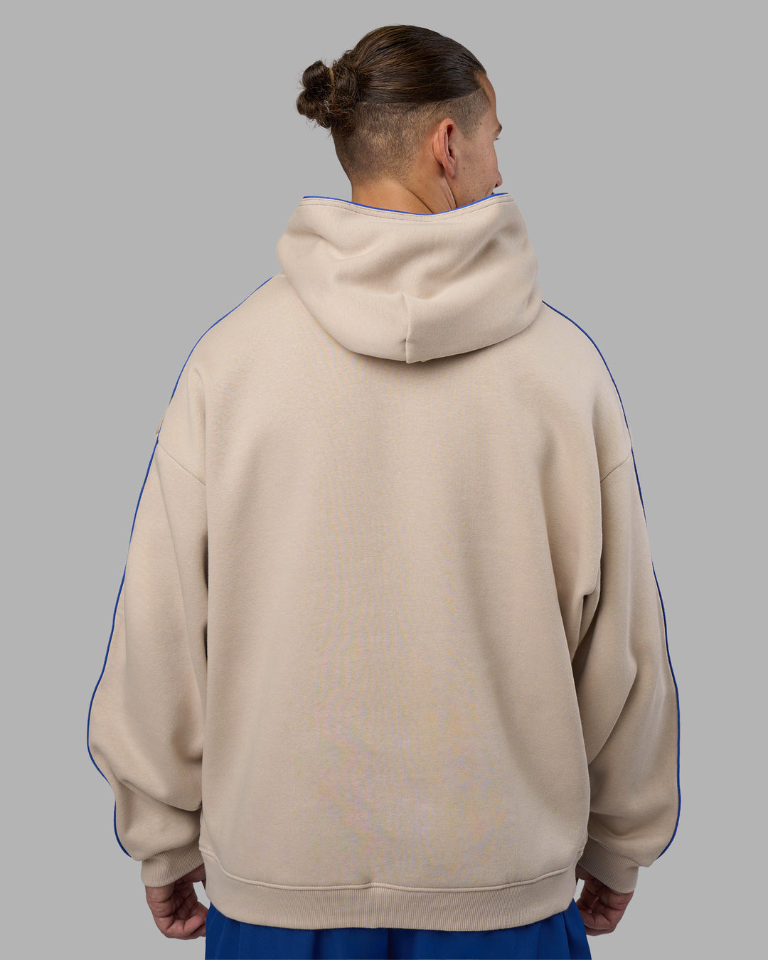 Man wearing Unisex Oversized Piping Hoodie - Shale Beige-Power Cobalt | Model:Jaiden | Size:M