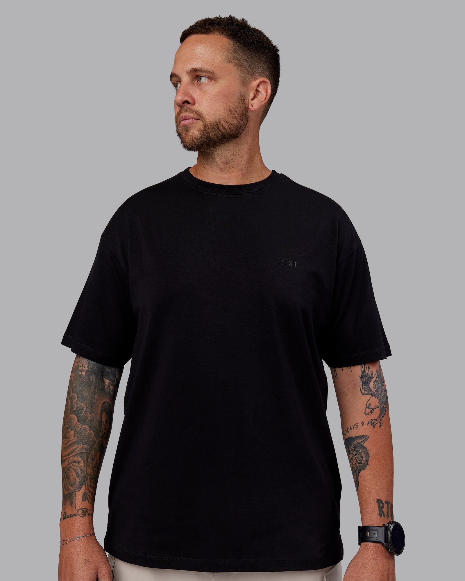 Man wearing Unisex PimaFLX Tee Oversize - Black | Model:Macca | Size:M