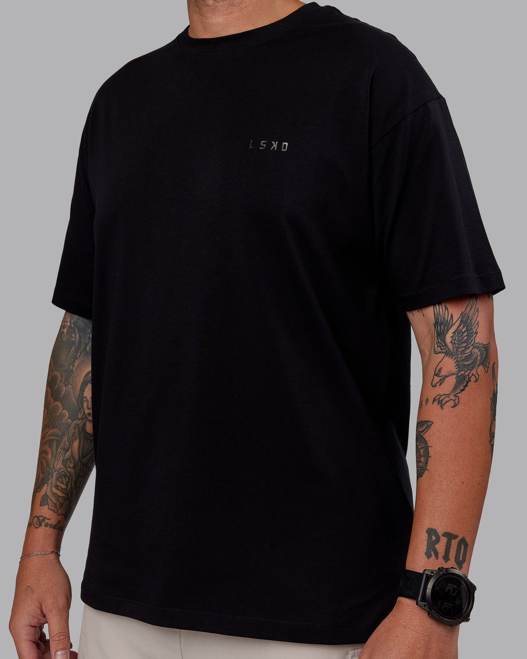 Man wearing Unisex PimaFLX Tee Oversize - Black | Model:Macca | Size:M