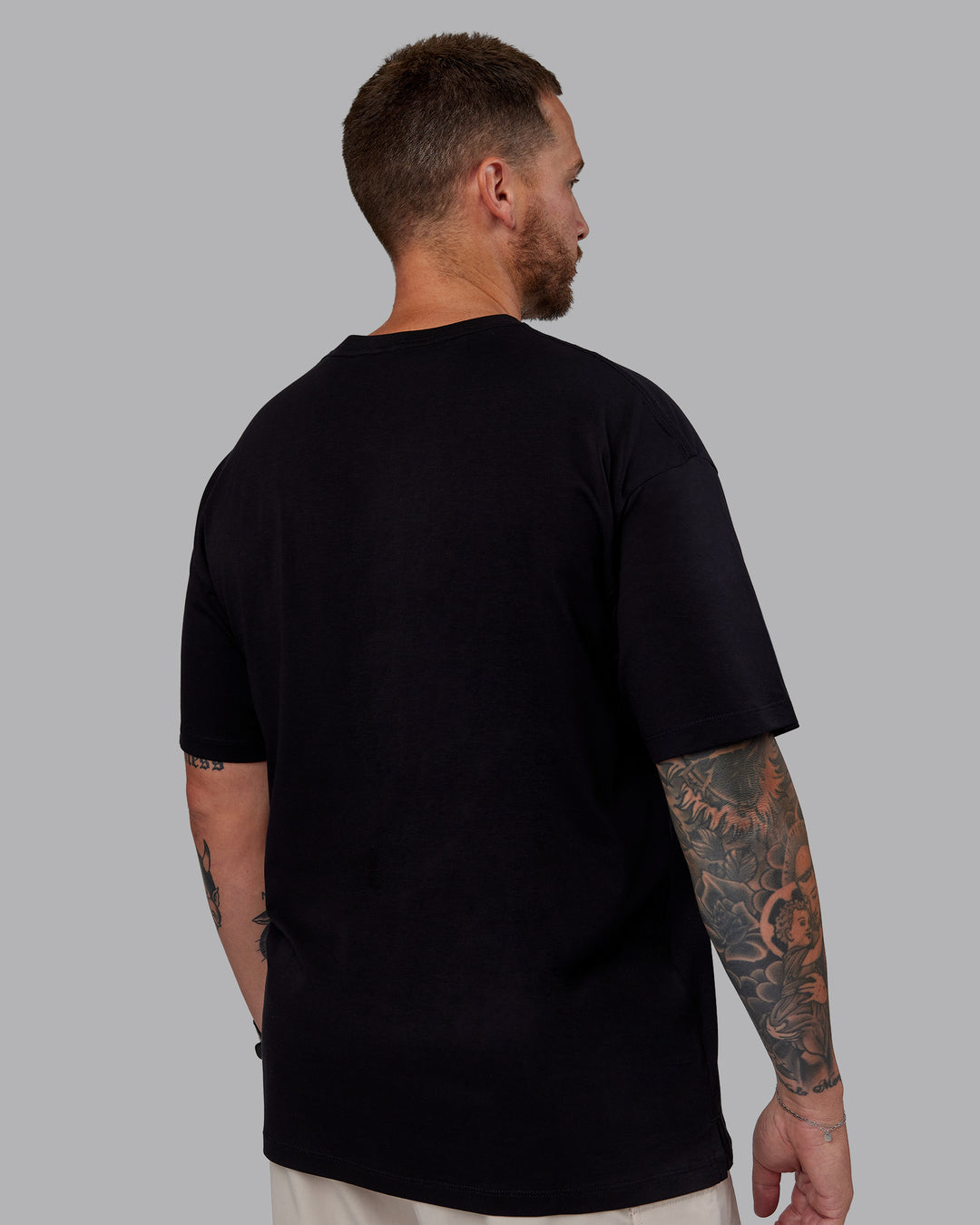 Man wearing Unisex PimaFLX Tee Oversize - Black | Model:Macca | Size:M