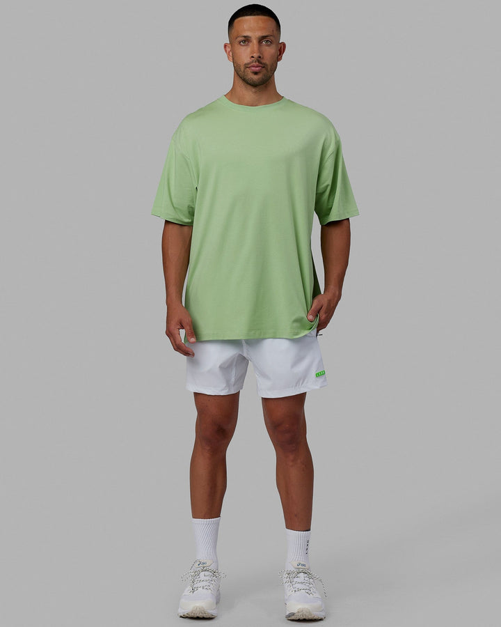 Man wearing Unisex PimaFLX Tee Oversize - Green Fig