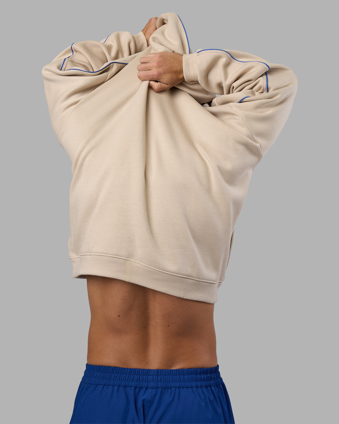 Man wearing Unisex Oversized Piping Hoodie - Shale Beige-Power Cobalt | Model:Jaiden | Size:M