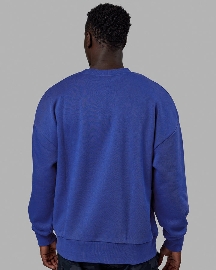 Man wearing Unisex 1% Better Sweater Oversize - Power Cobalt-White