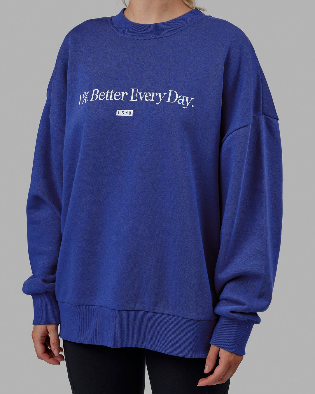 Woman wearing Unisex 1% Better Sweater Oversize - Power Cobalt-White