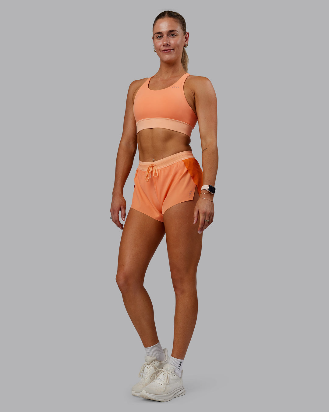 Woman wearing Accelerate Sports Bra - Cantaloupe Colourblock