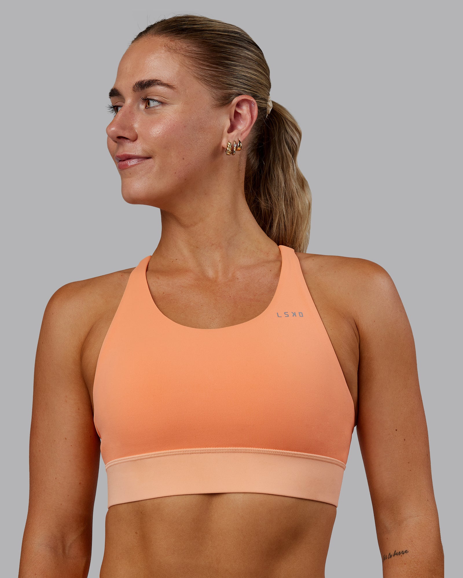 Woman wearing Accelerate Sports Bra - Cantaloupe Colourblock
