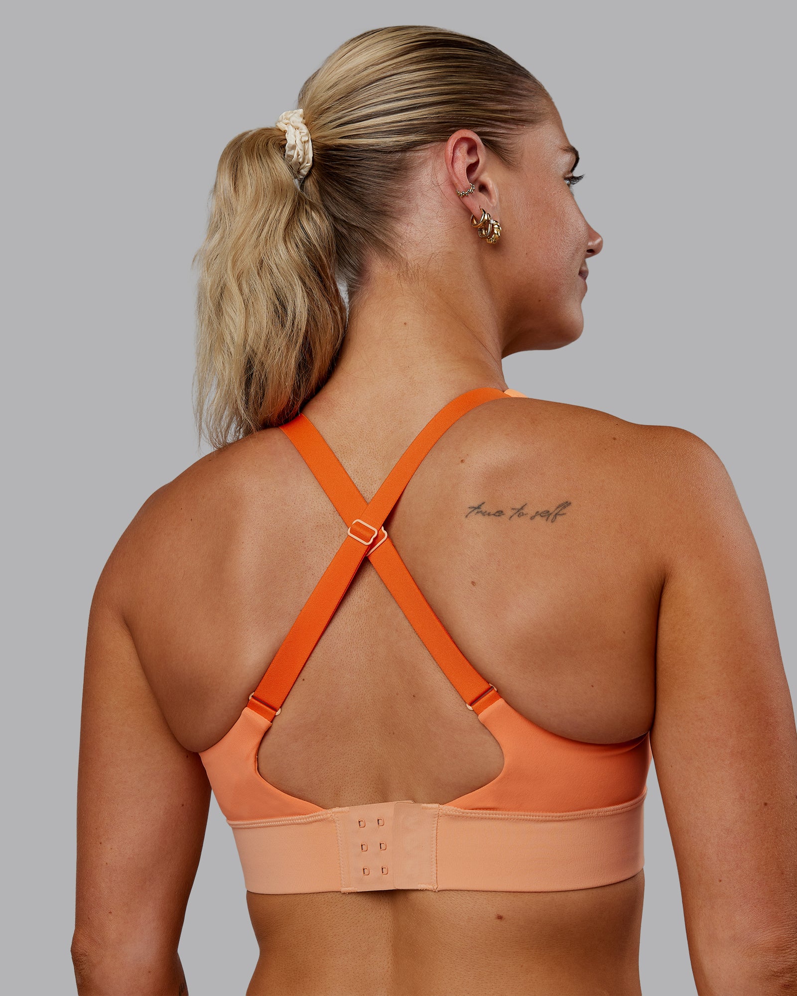 Woman wearing Accelerate Sports Bra - Cantaloupe Colourblock