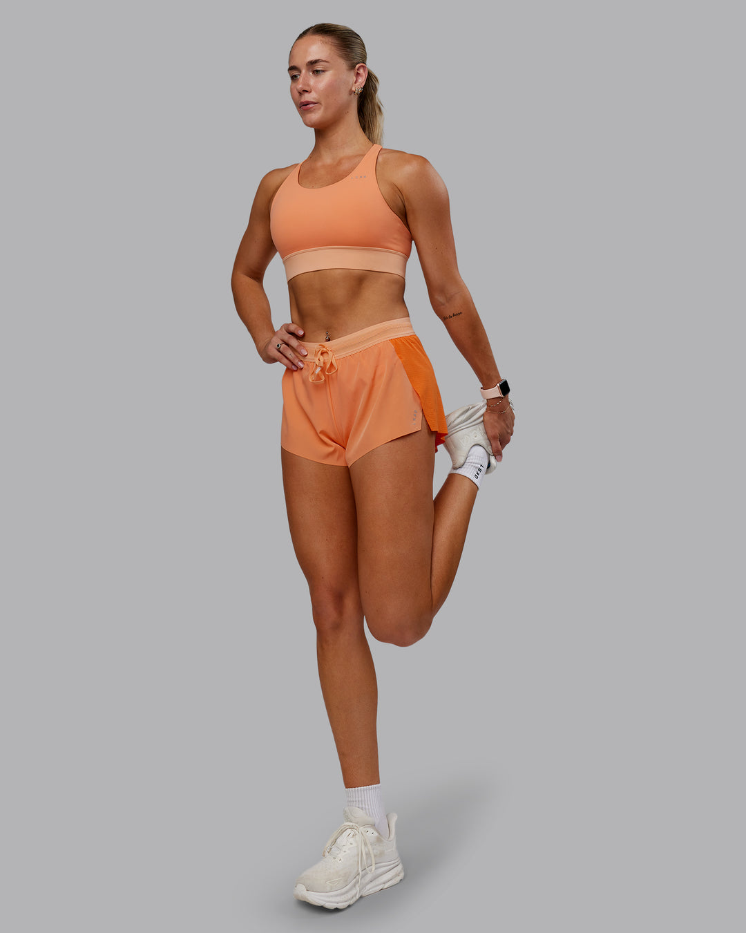 Woman wearing Accelerate Sports Bra - Cantaloupe Colourblock