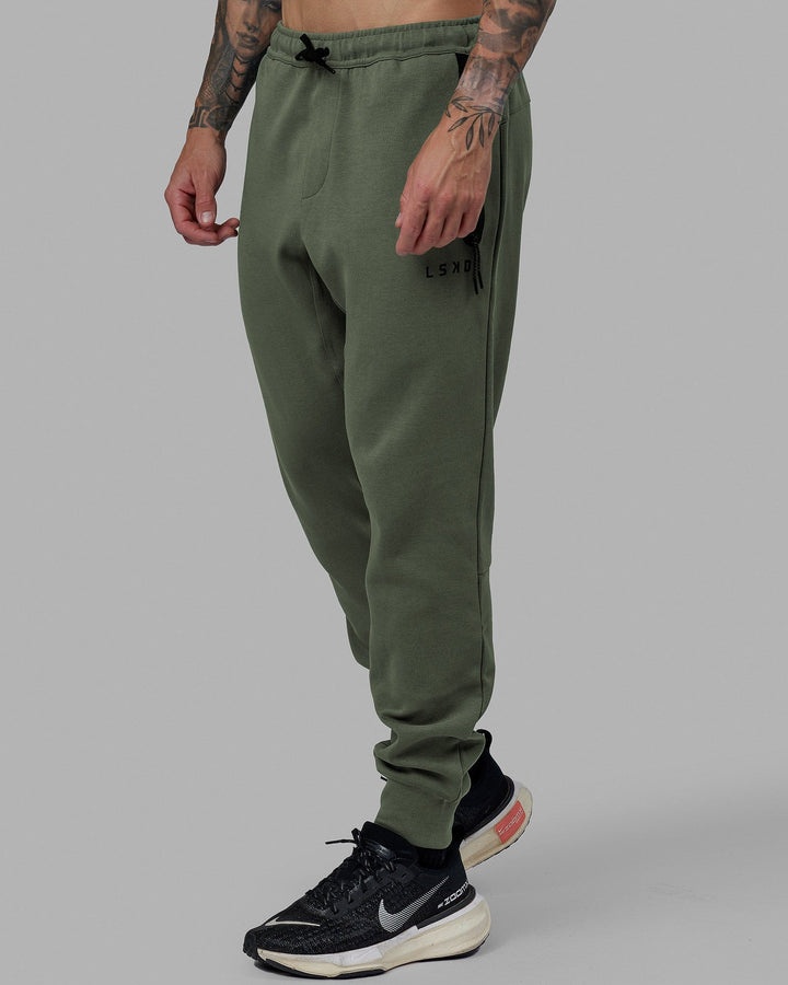 Man wearing Athlete ForgedFleece Zip Track Pants - Dark Forest