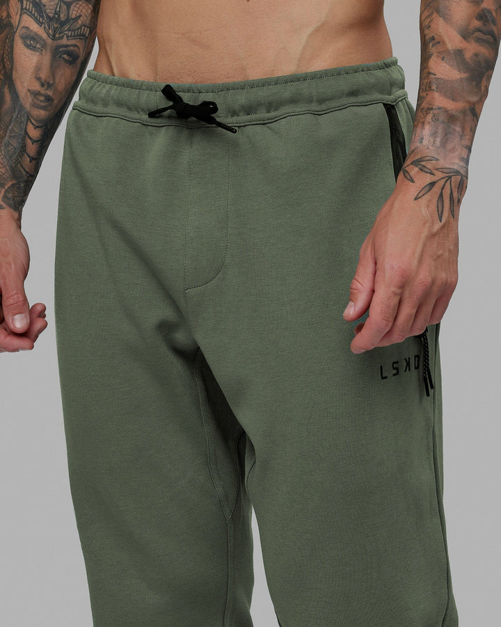 Man wearing Athlete ForgedFleece Zip Track Pants - Dark Forest