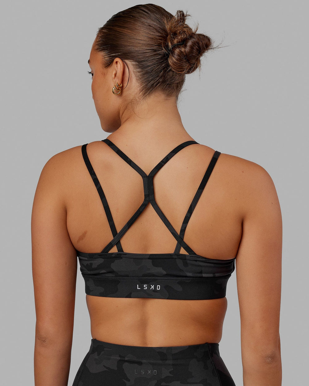 Woman wearing Bridge Sports Bra - Black Camo