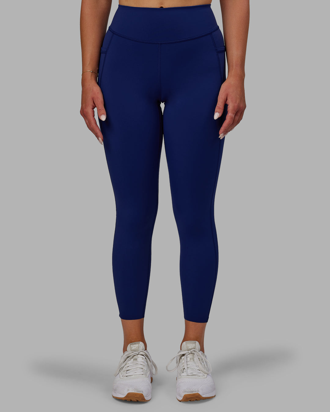 Woman wearing Elite High-Rise 7/8 Legging Pockets - Midnight Blue