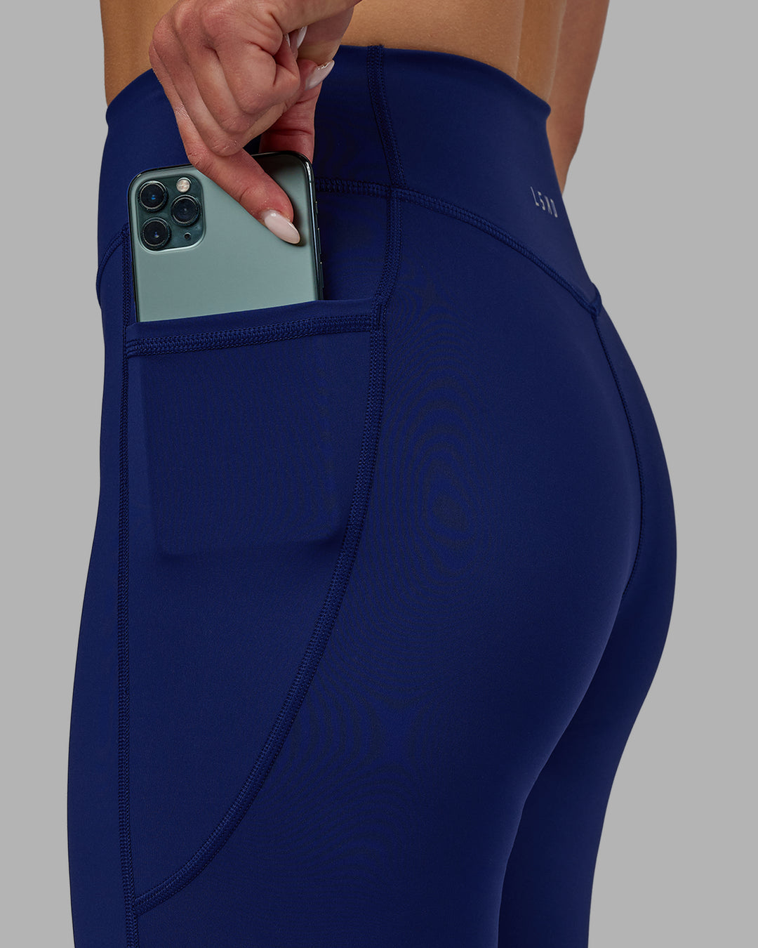 Woman wearing Elite High-Rise 7/8 Legging Pockets - Midnight Blue