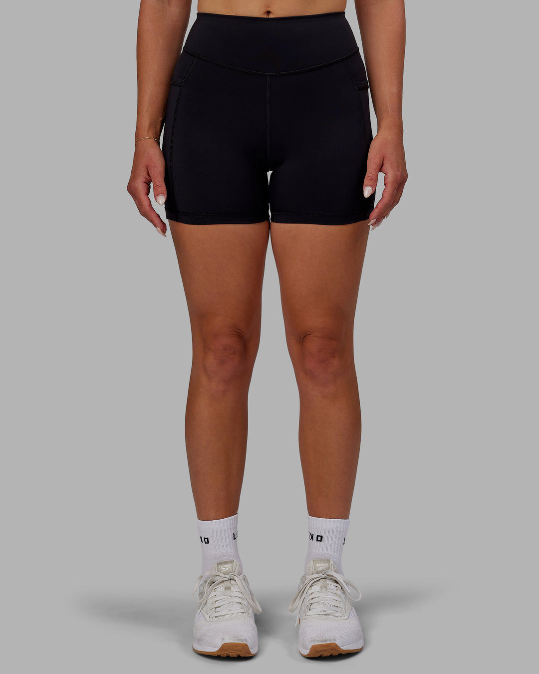 Woman wearing Elite High-Rise 4&quot; Short Pockets - Black