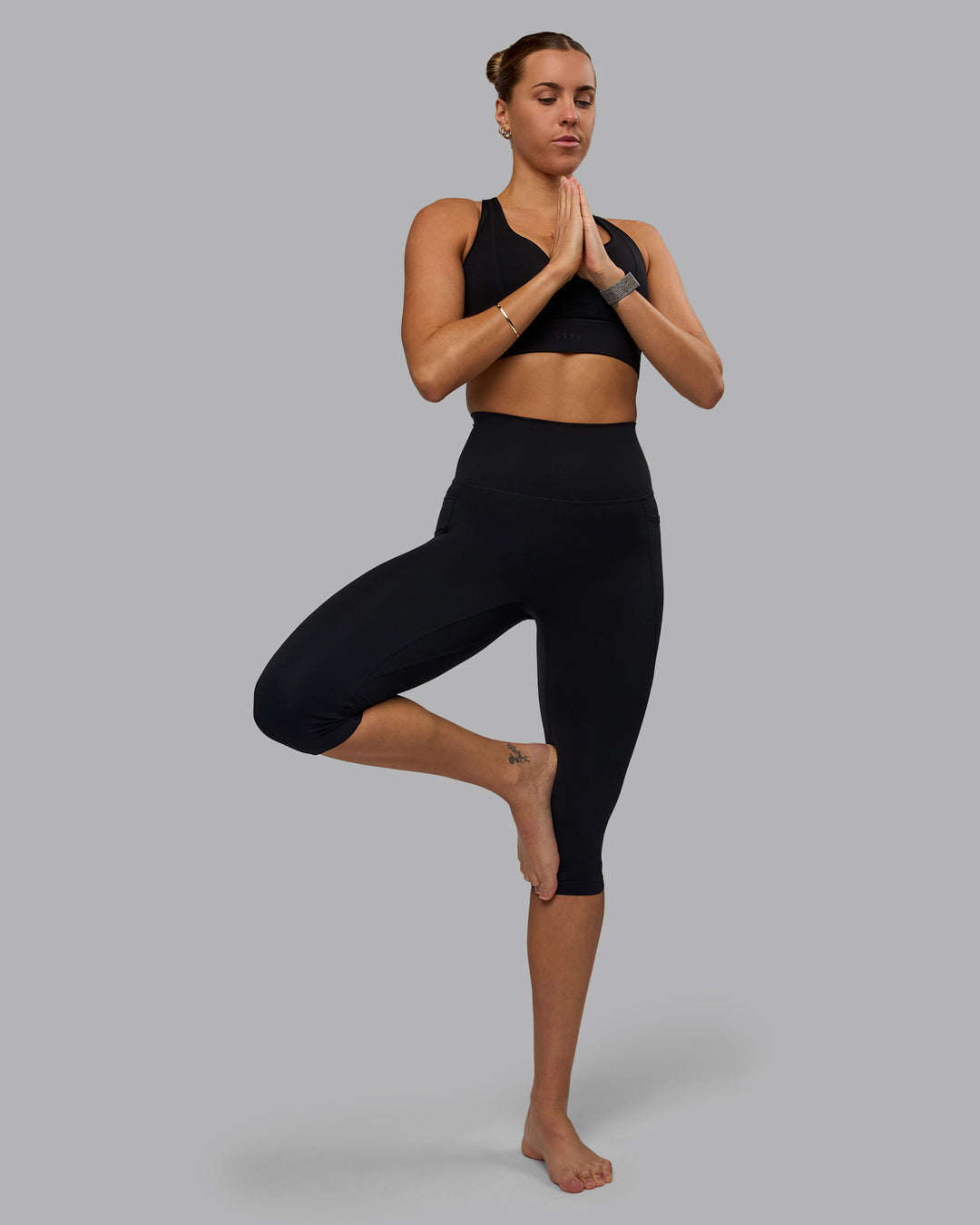 Woman wearing Elixir Ultra High-Rise 3/4 Legging Pockets - Black | Model:Shae | Size:S