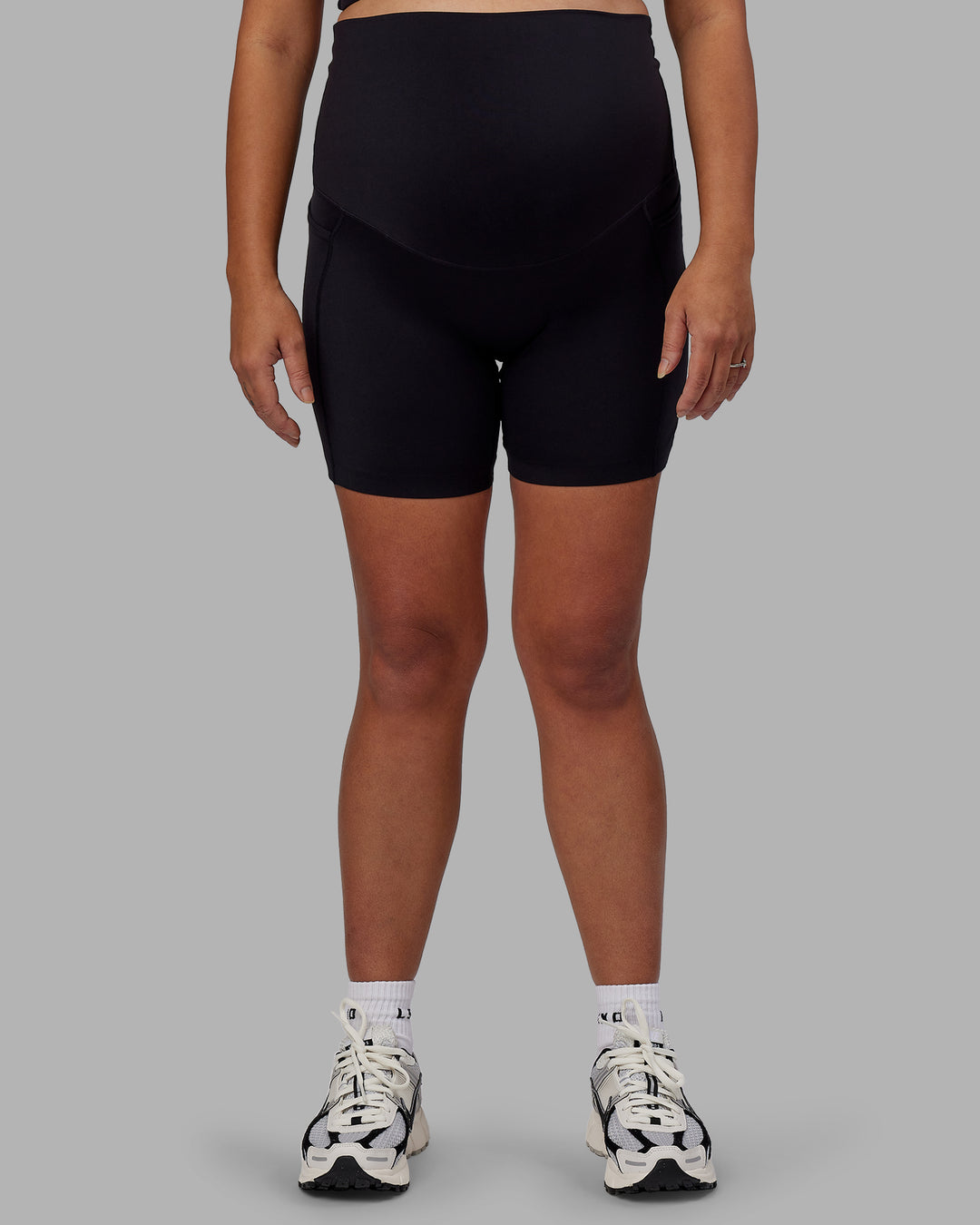 Woman wearing Elixir Ultra High-Rise Maternity 6&quot; Short Pockets - Black | Model:Jojo | Size:M