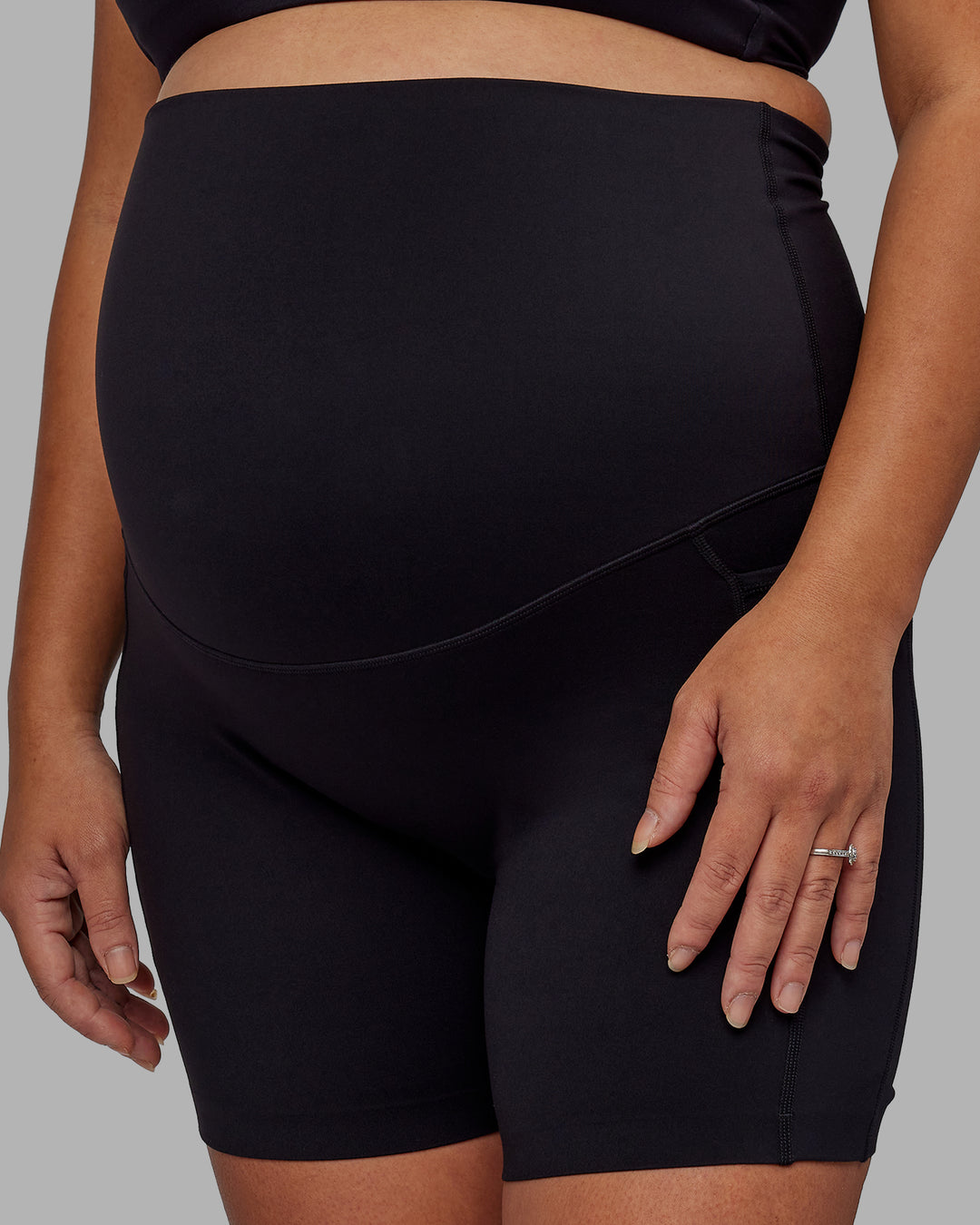Woman wearing Elixir Ultra High-Rise Maternity 6&quot; Short Pockets - Black | Model:Jojo | Size:M