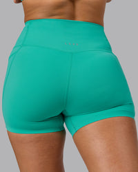 Woman wearing Elixir Ultra High-Rise 4" Short Pockets - Atlantis | Model:Sophie | Size:S