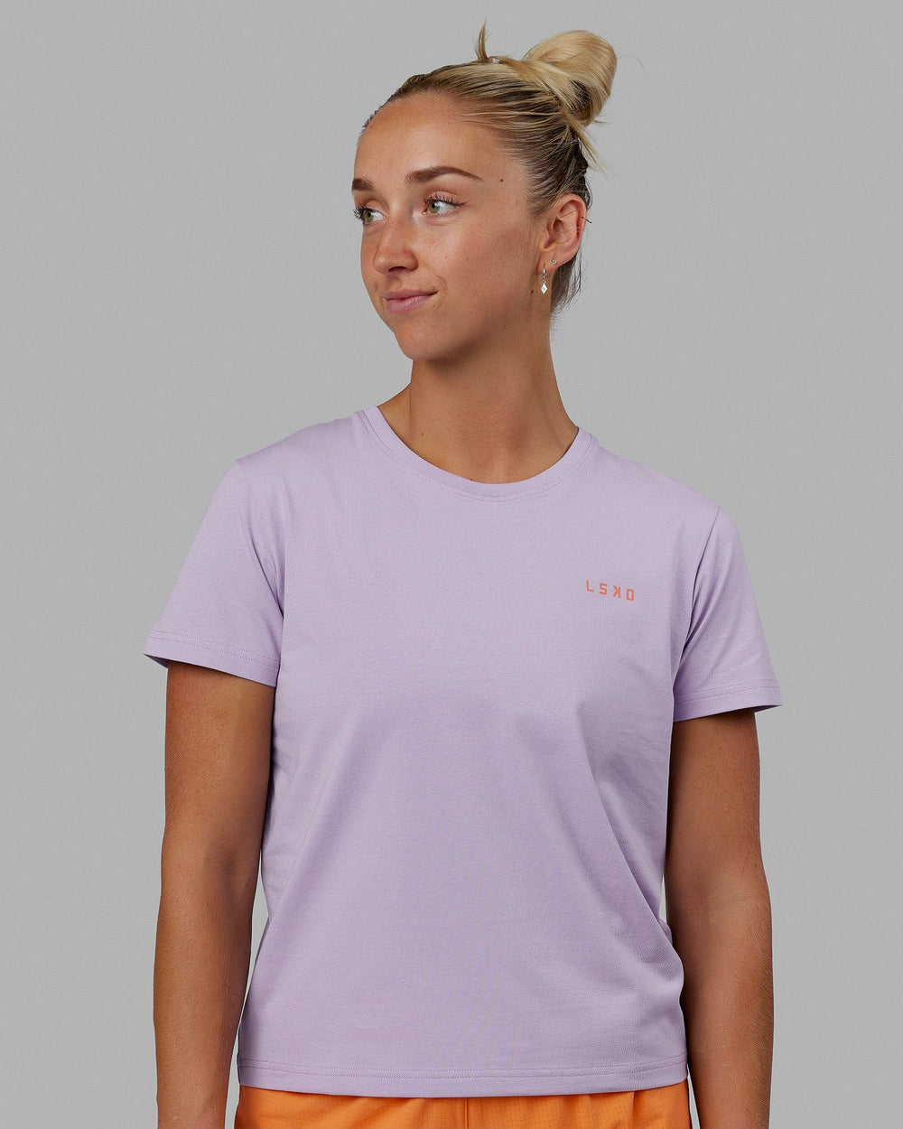 Woman wearing Endeavour FLX Cotton Tee - Pale Lilac-Impact Orange