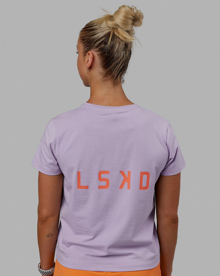 Woman wearing Endeavour FLX Cotton Tee - Pale Lilac-Impact Orange