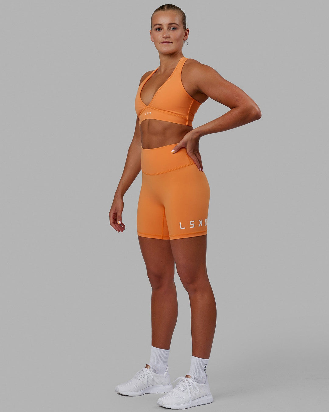 Woman wearing Evolved Mid Short Tight - Tangerine