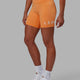 Woman wearing Evolved Mid Short Tight - Tangerine