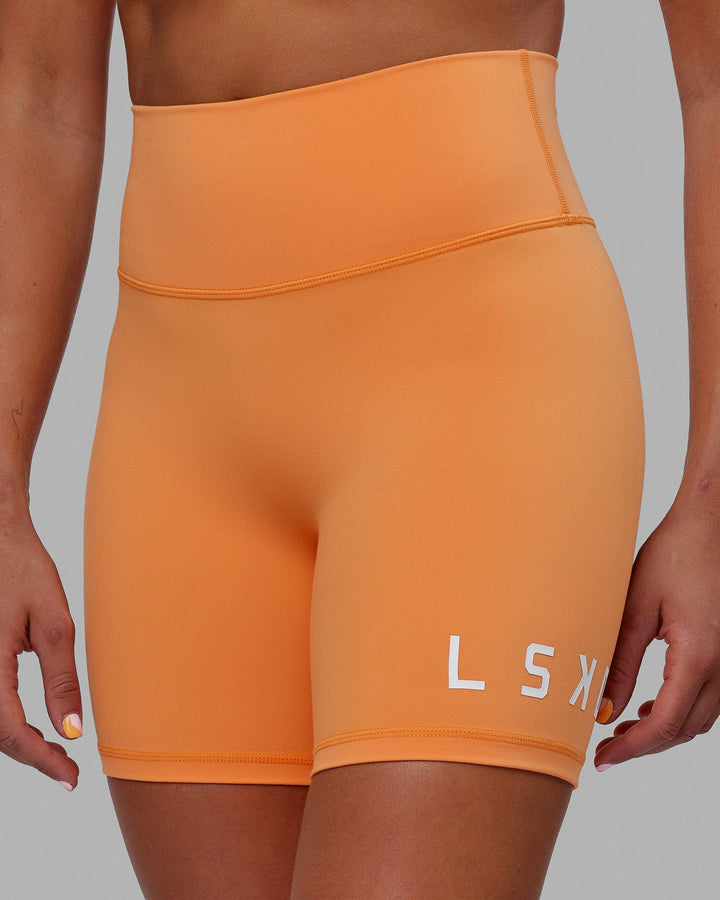 Woman wearing Evolved Mid Short Tight - Tangerine