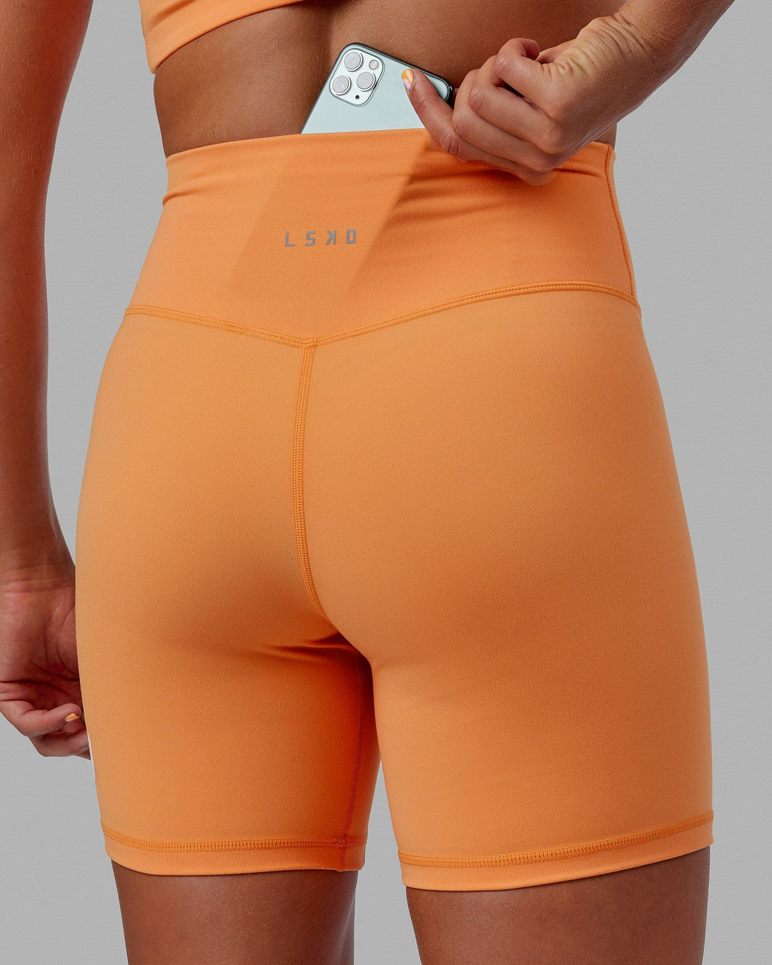 Woman wearing Evolved Mid Short Tight - Tangerine