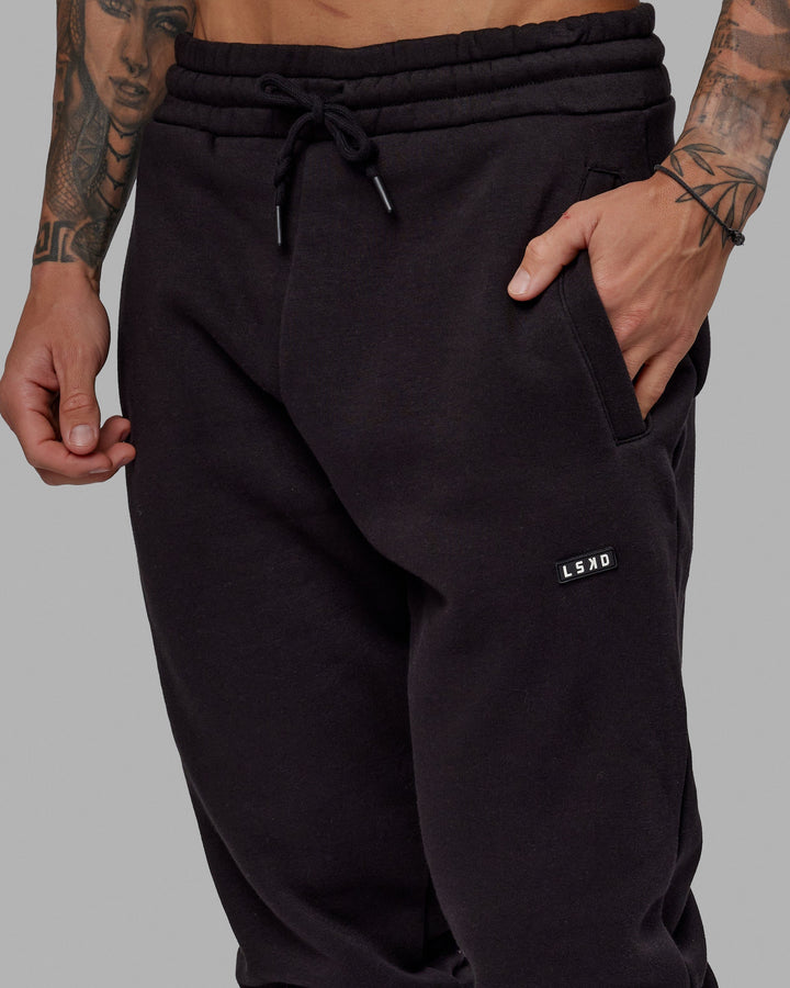 Man wearing Unisex Fundamental Track Pant - Black