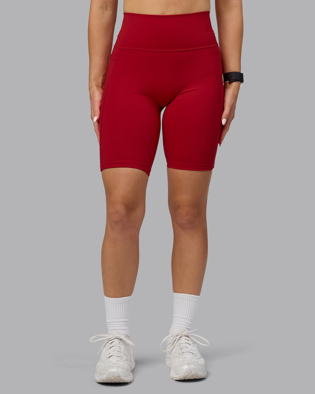 Woman wearing Fusion Ultra High-Rise 9&quot; Short Pockets - Cherry Red | Model:Halle | Size:S