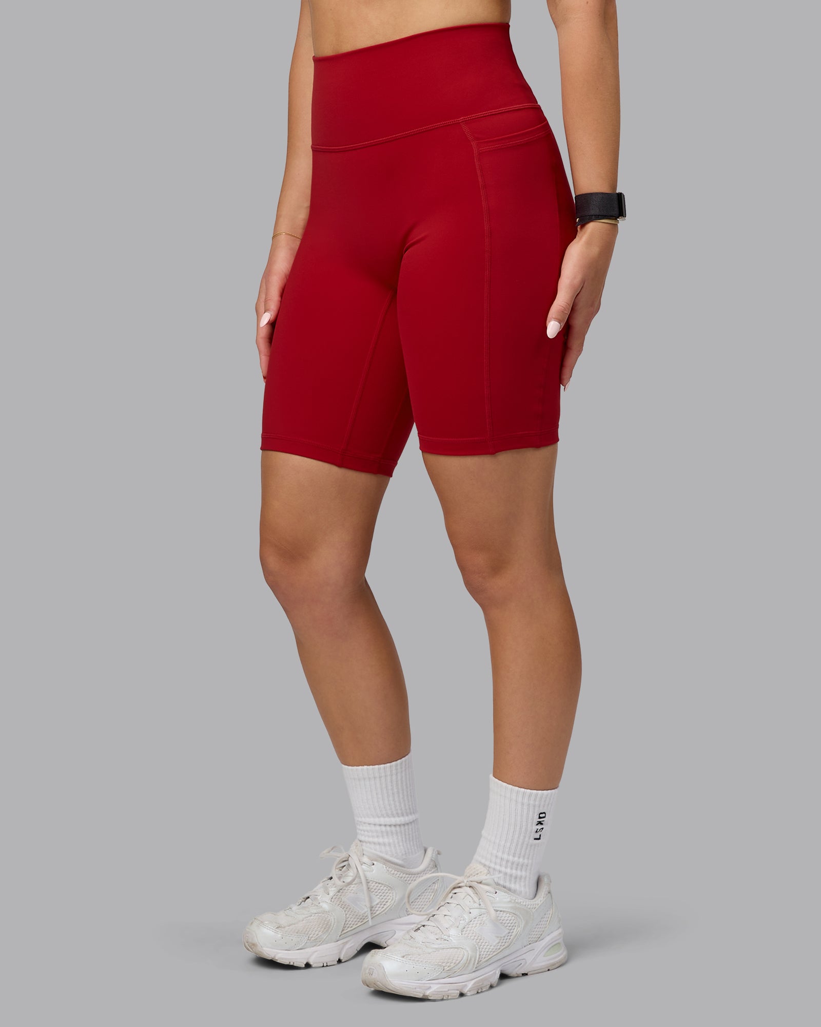 Woman wearing Fusion Ultra High-Rise 9" Short Pockets - Cherry Red | Model:Halle | Size:S