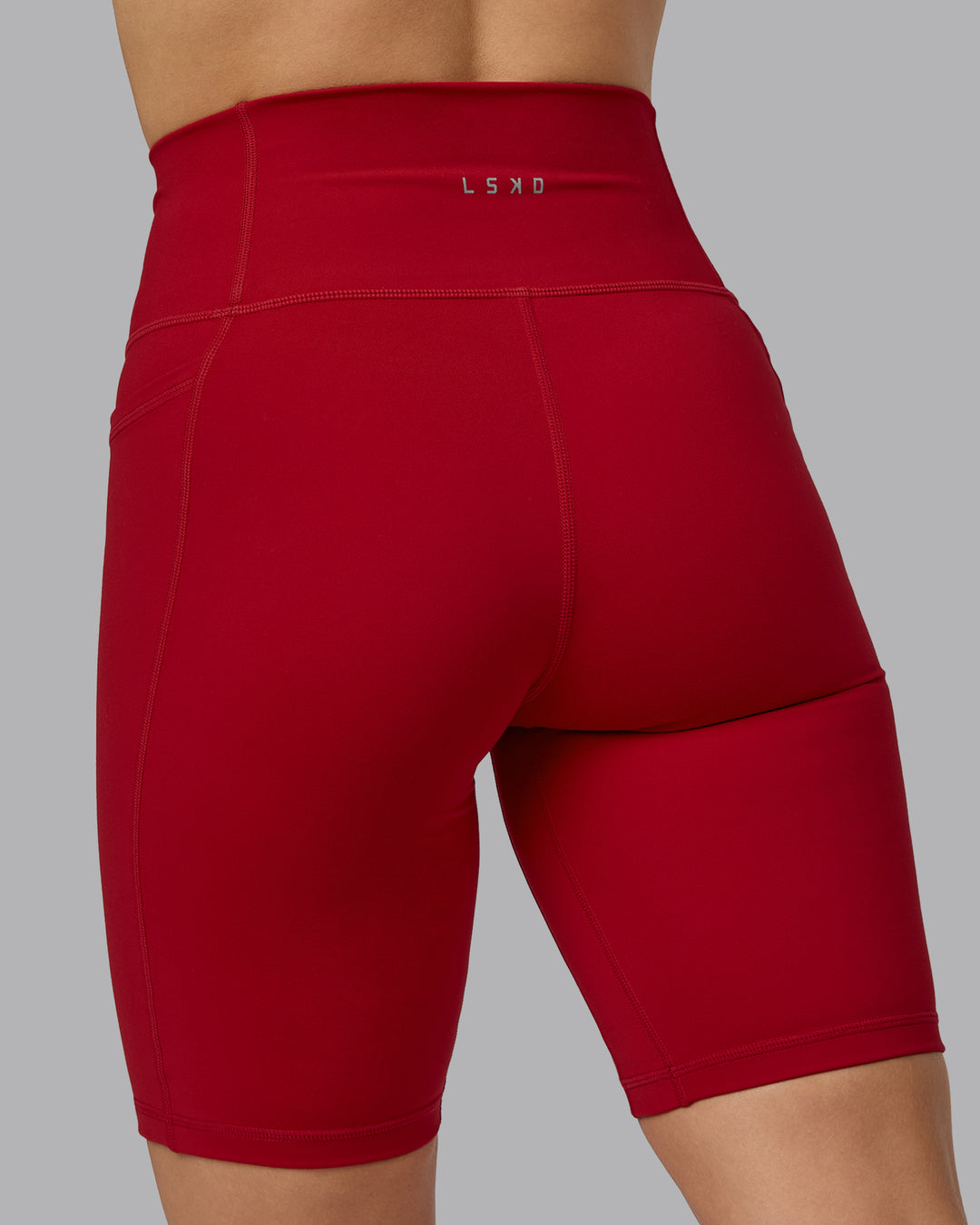 Woman wearing Fusion Ultra High-Rise 9&quot; Short Pockets - Cherry Red | Model:Halle | Size:S