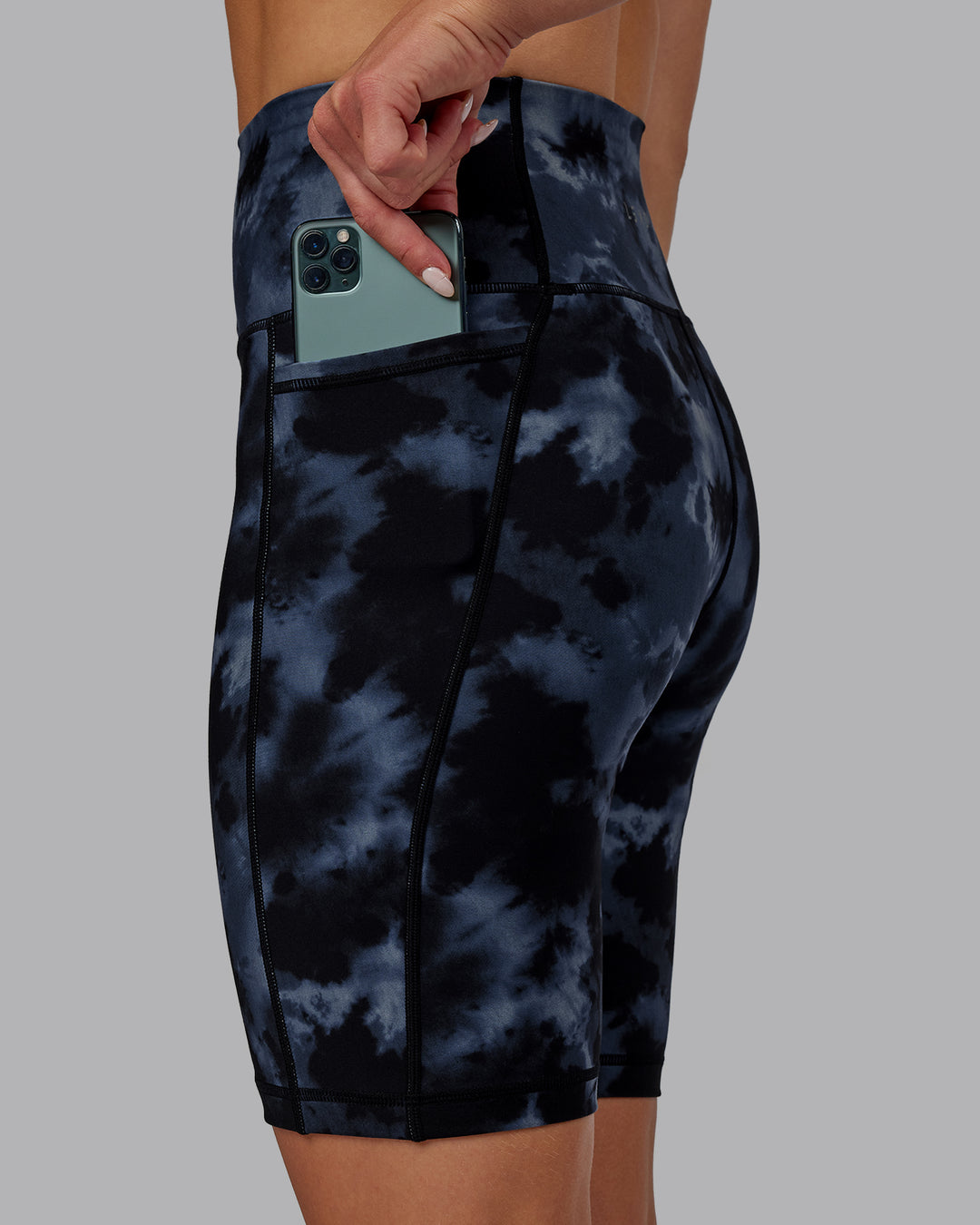 Woman wearing Fusion Ultra High-Rise 9&quot; Short Pockets - Tie Dye-Midnight | Model:Halle | Size:S