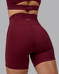 Woman wearing Fusion Ultra High-Rise 6" Short Pockets - Cordovan | Model:Chloe | Size:XS