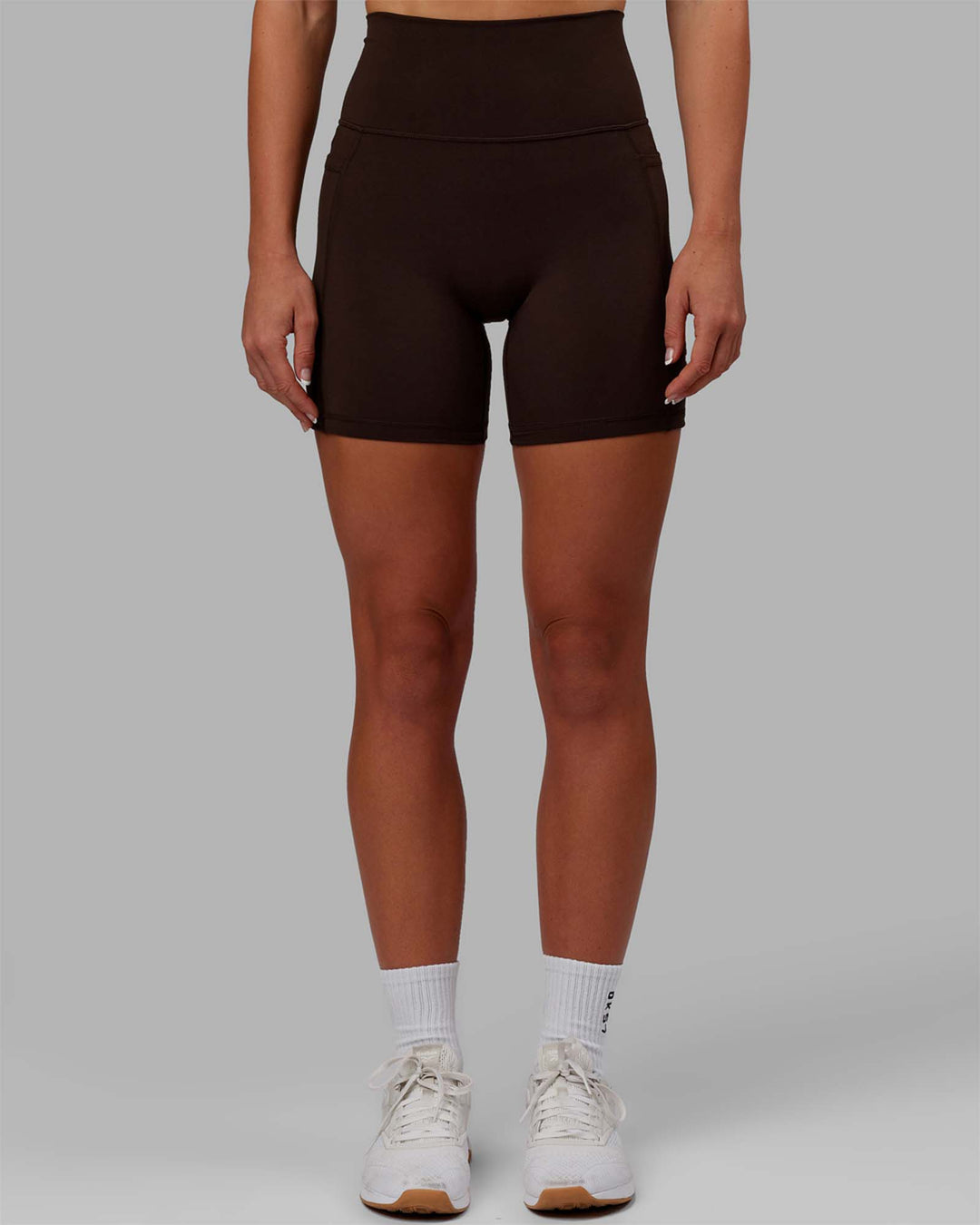 Woman wearing Fusion Ultra High-Rise 6&quot; Short Pockets - Dark Chocolate | Model:Emelia | Size:XS
