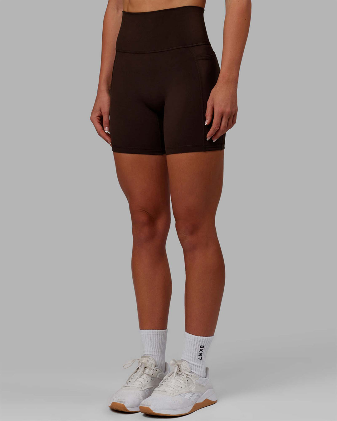 Woman wearing Fusion Ultra High-Rise 6&quot; Short Pockets - Dark Chocolate | Model:Emelia | Size:XS