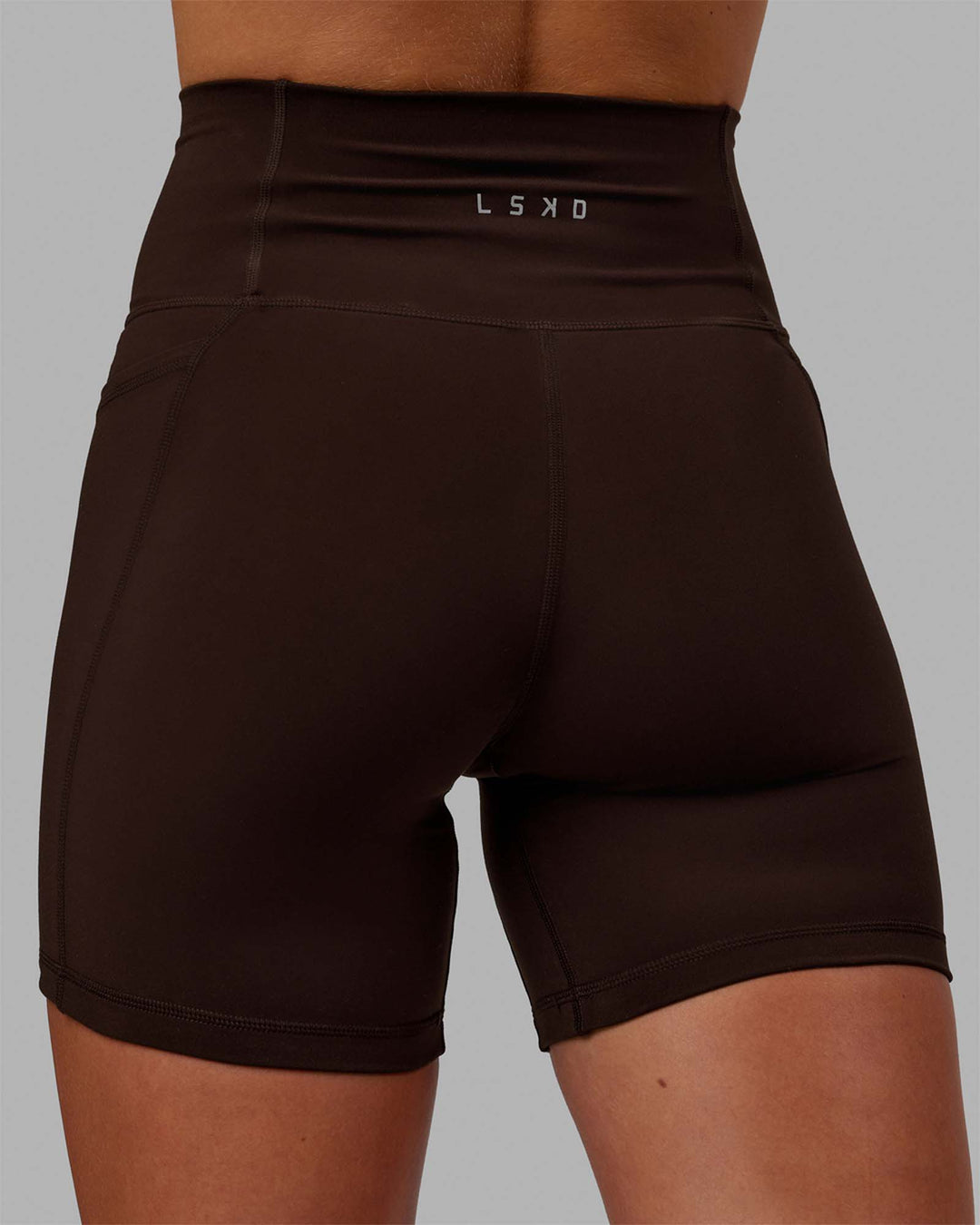 Woman wearing Fusion Ultra High-Rise 6&quot; Short Pockets - Dark Chocolate | Model:Emelia | Size:XS
