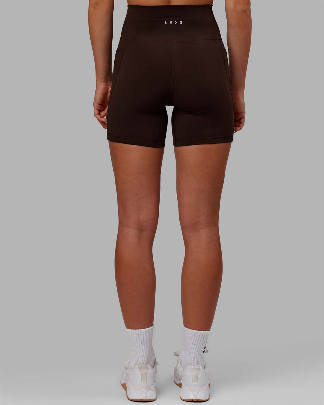 Woman wearing Fusion Ultra High-Rise 6&quot; Short Pockets - Dark Chocolate | Model:Emelia | Size:XS
