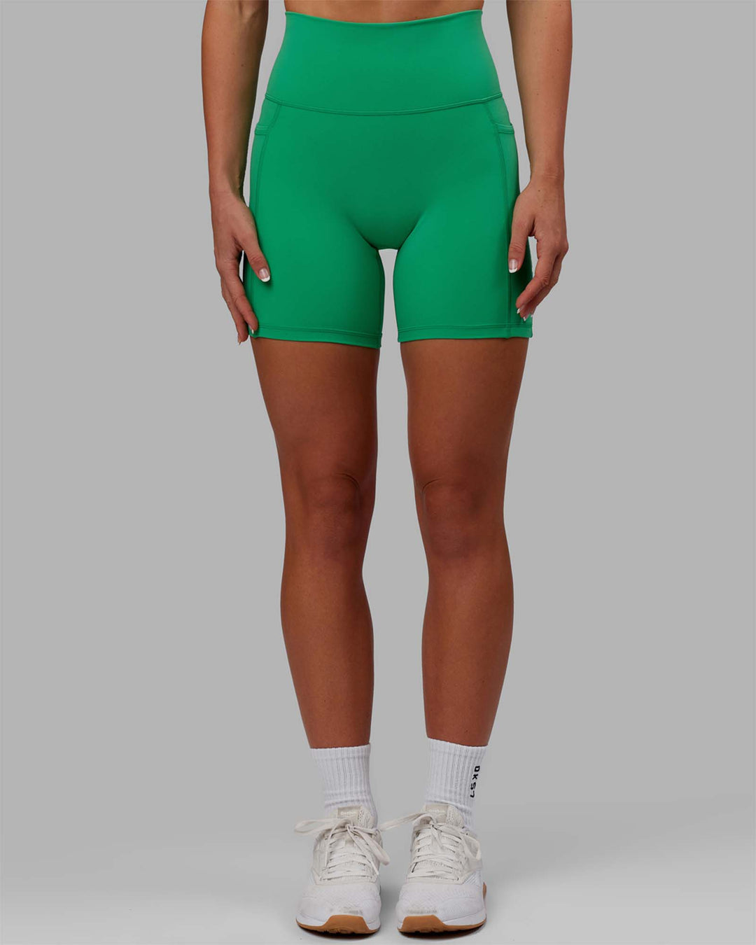 Woman wearing Fusion Ultra High-Rise 6&quot; Short Pockets - Holly Green | Model:Emilia | Size:XS