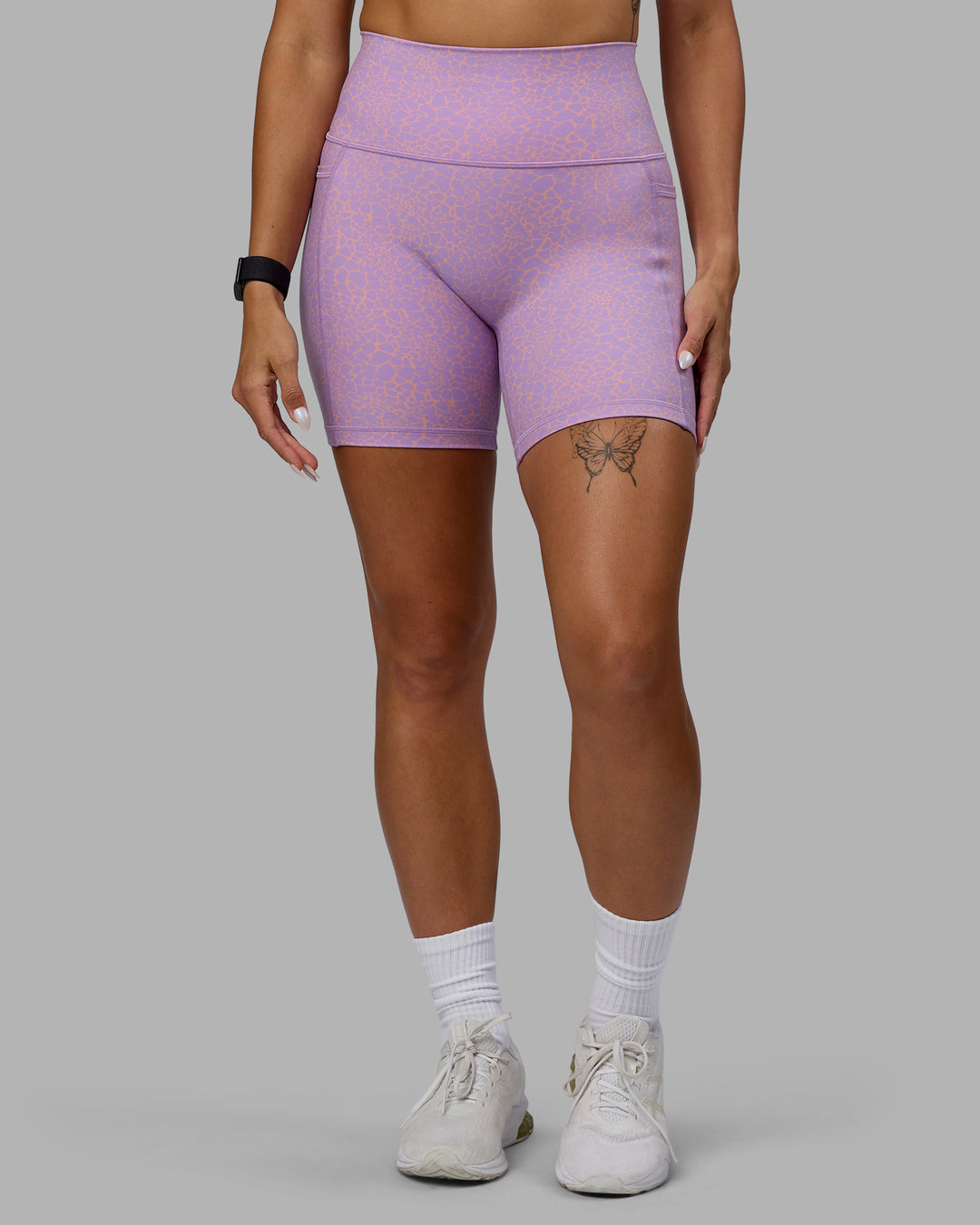 Woman wearing Fusion Ultra High-Rise 6&quot; Short Pockets - Pale Lilac Vitality Print | Model:Vanessa | Size:S
