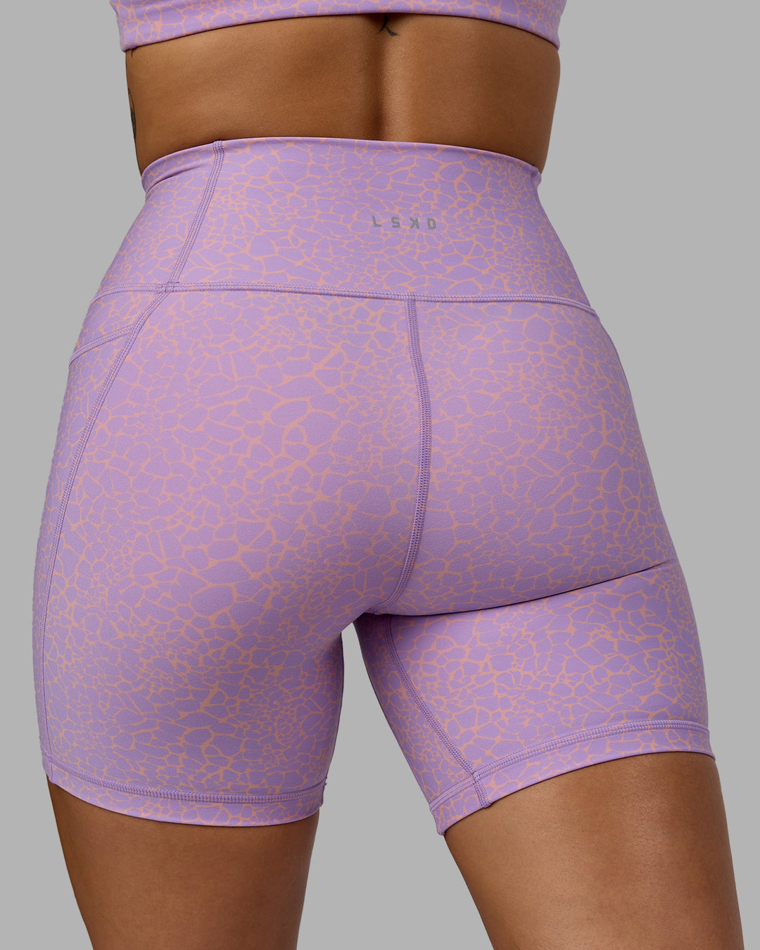 Woman wearing Fusion Ultra High-Rise 6&quot; Short Pockets - Pale Lilac Vitality Print | Model:Vanessa | Size:S
