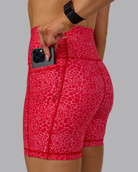 Woman wearing Fusion Ultra High-Rise 6" Short Pockets - Red Vitality Print | Model:Halle | Size:S