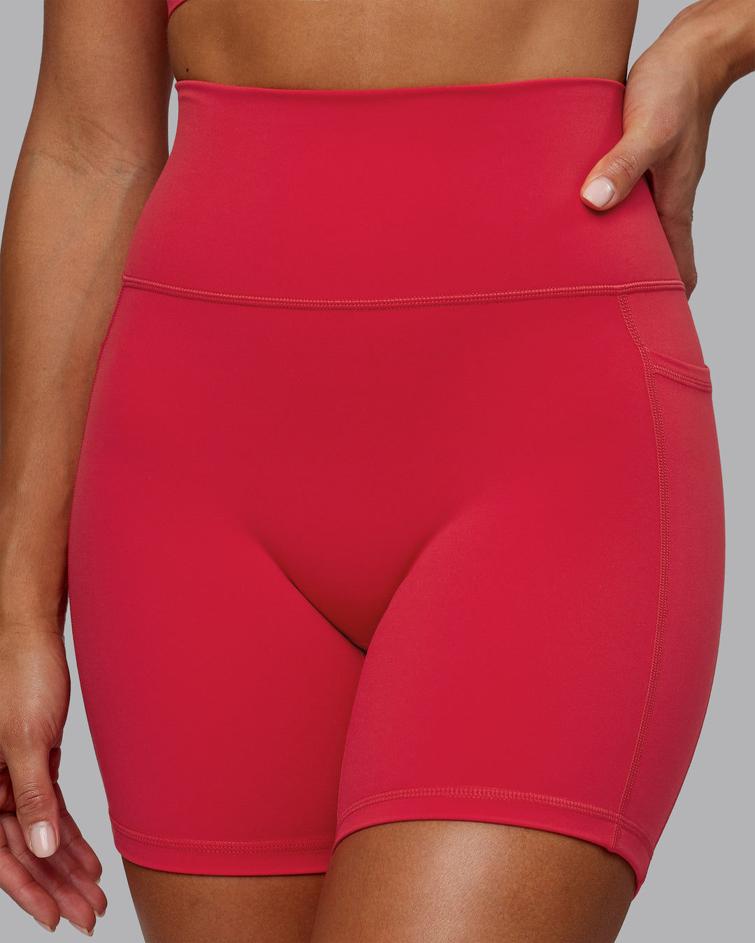 Woman wearing Fusion Ultra High-Rise 6" Short Pockets - Scarlet | Model:Demi | Size:S