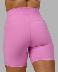 Woman wearing Fusion Ultra High-Rise 6" Short Pockets - Spark Pink | Model:Halle | Size:S