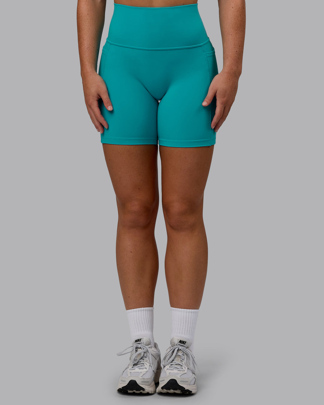 Woman wearing Fusion Ultra High-Rise 6" Short Pockets - Uplift Blue | Set:true | Angle:front | Model:Monique | Size:S