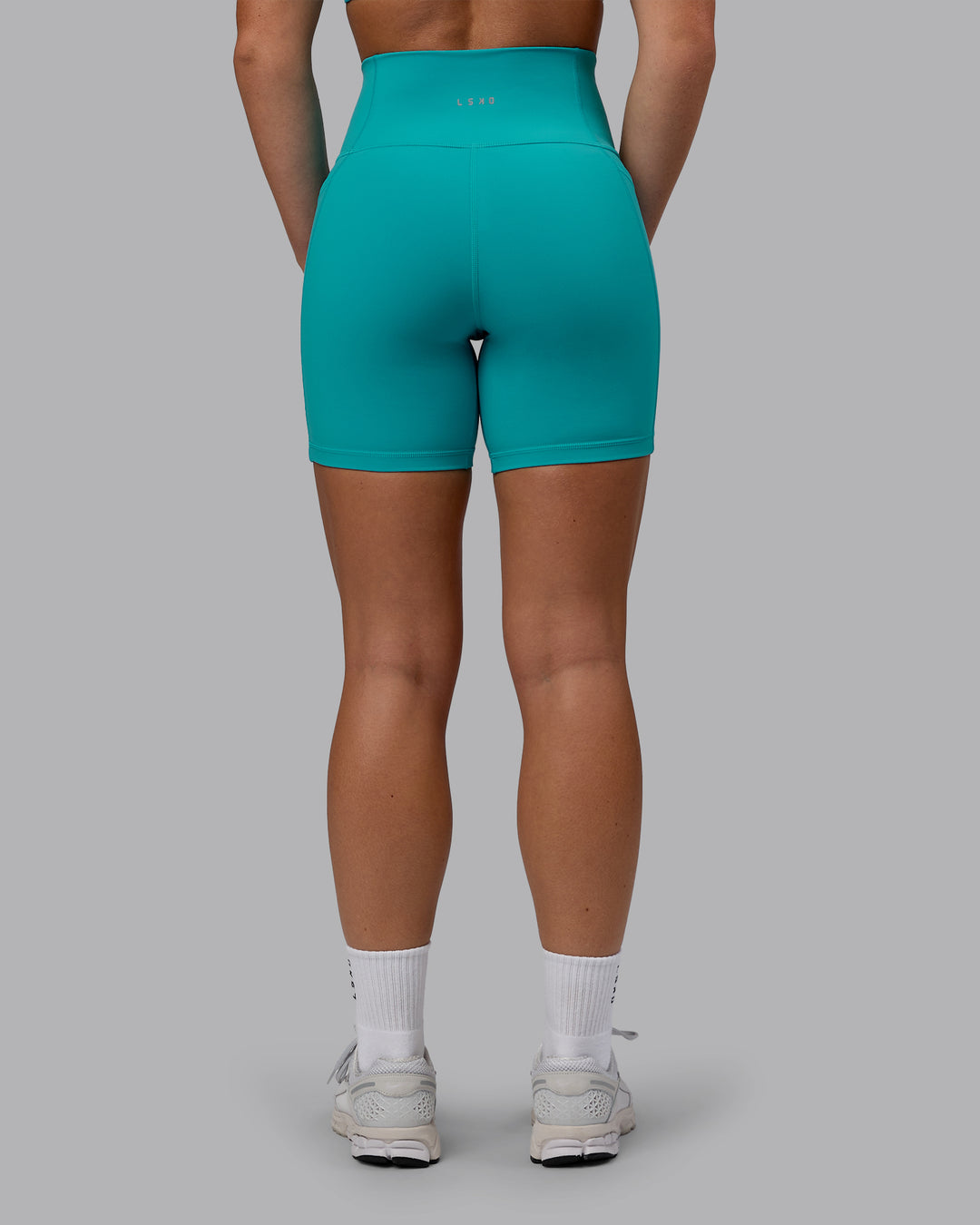 Woman wearing Fusion Ultra High-Rise 6" Short Pockets - Uplift Blue | Set:true | Angle:back | Model:Monique | Size:S