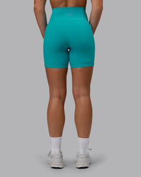 Woman wearing Fusion Ultra High-Rise 6" Short Pockets - Uplift Blue | Set:true | Angle:back | Model:Monique | Size:S