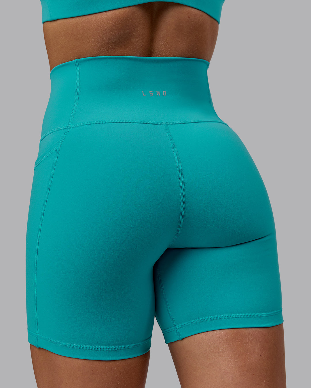 Woman wearing Fusion Ultra High-Rise 6" Short Pockets - Uplift Blue | Model:Monique | Size:S